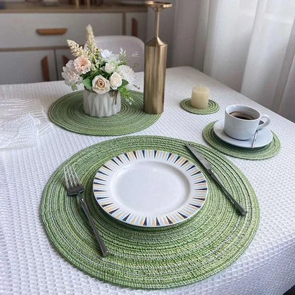 a white table with a green placemat and place settings