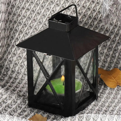a black lantern with a green candle inside