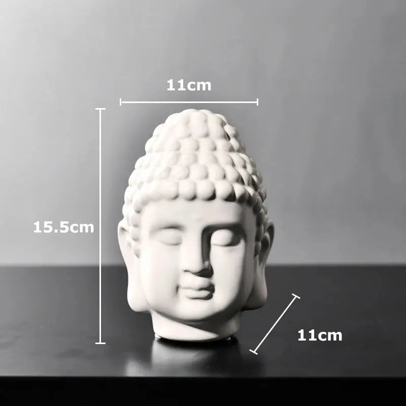a white buddha head sitting on top of a table
