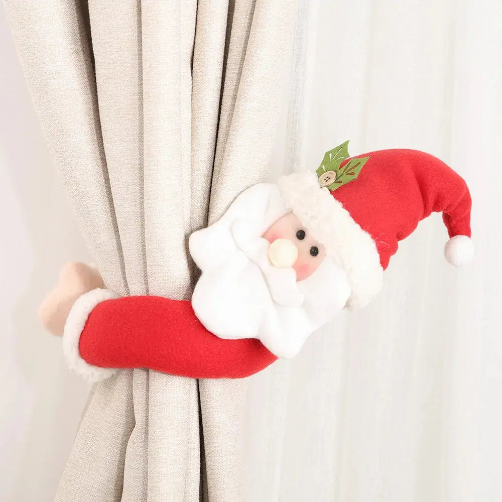 a stuffed santa clause hanging from a curtain