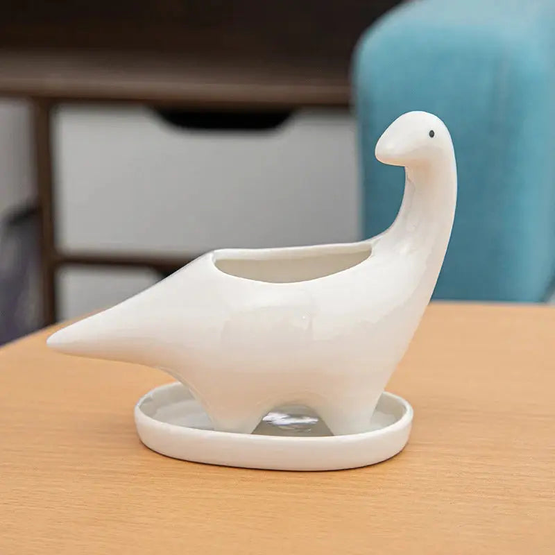 a white ceramic bird sitting on top of a wooden table