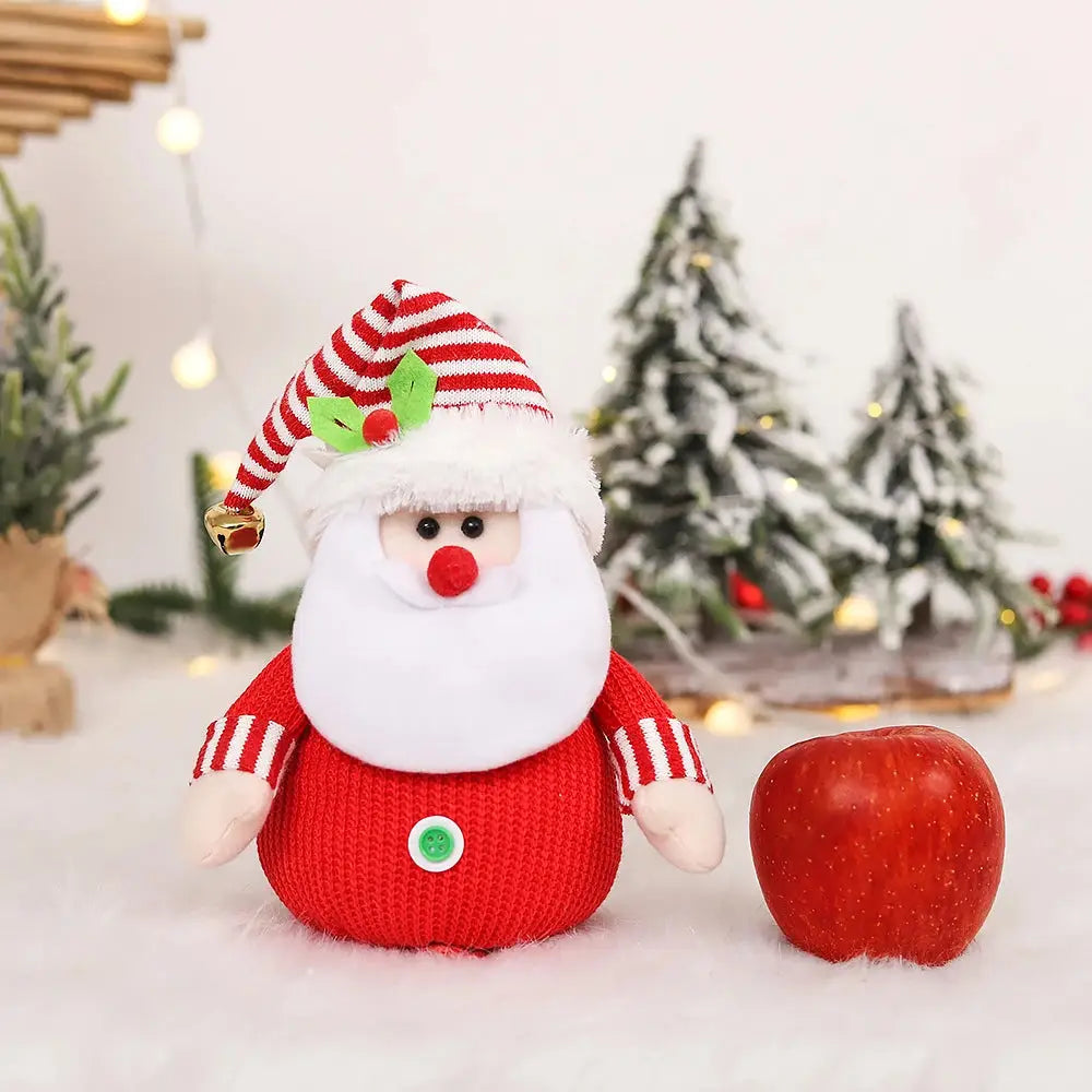 a santa clause doll next to an apple