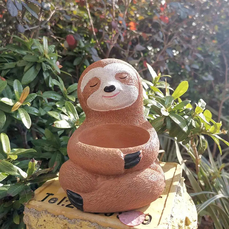 a statue of a sloth sitting on a rock