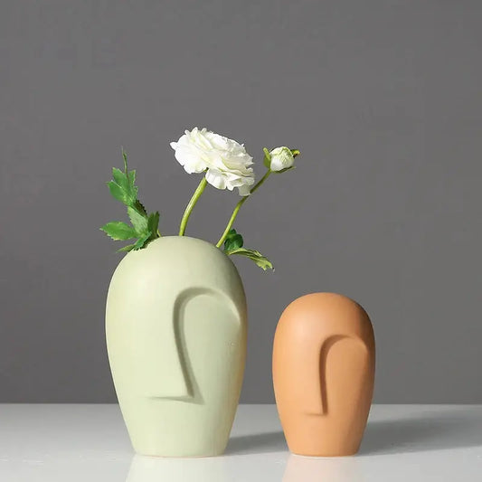 two vases with flowers in them sitting on a table