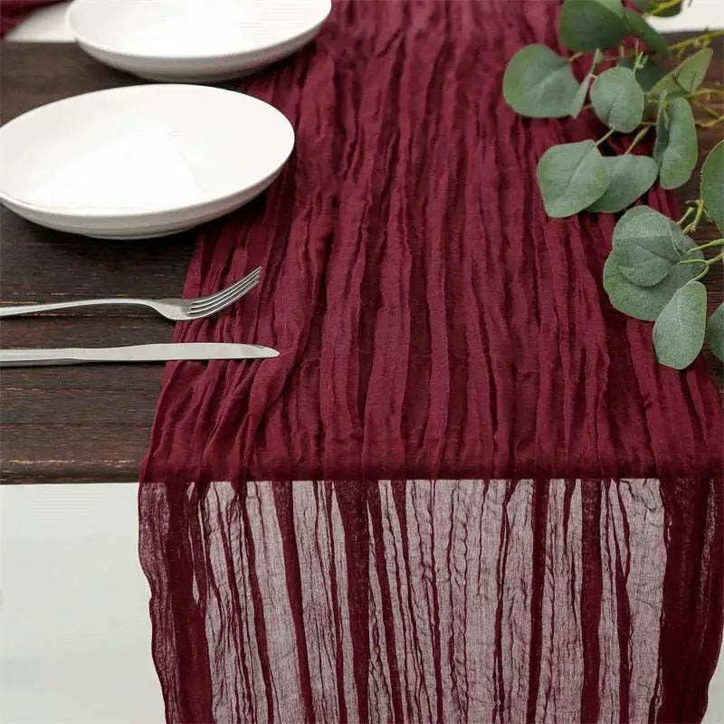 a table with a red table runner and white plates