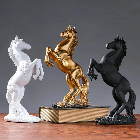 three statues of horses on a wooden table