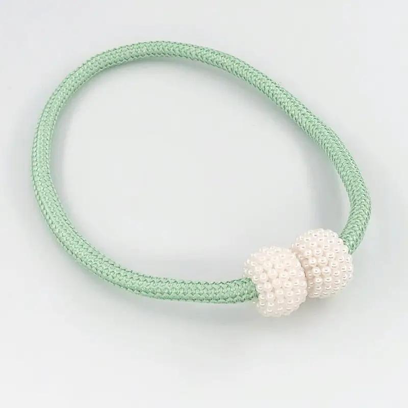 a green and white bracelet with two white beads