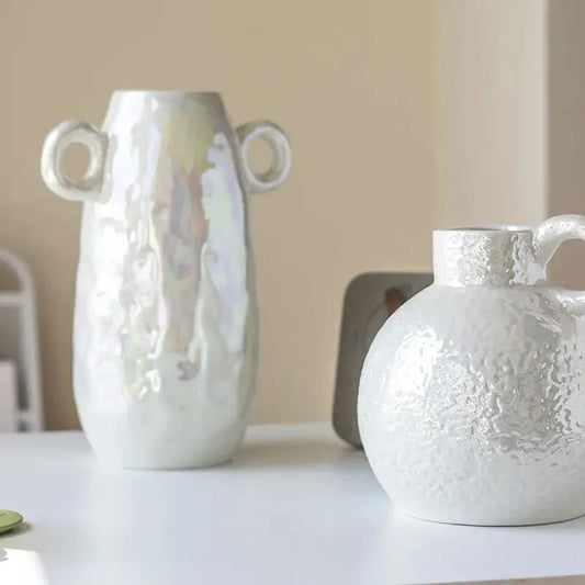 a couple of white vases sitting on top of a table