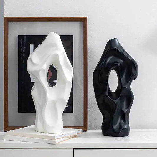 a couple of black and white vases sitting on top of a table