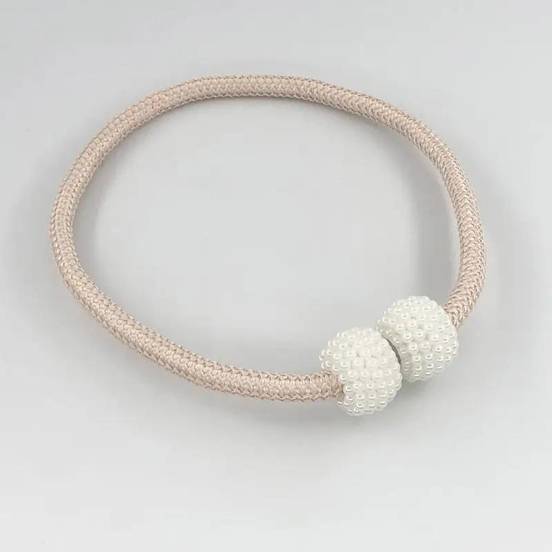 a white bracelet with two white beads on it