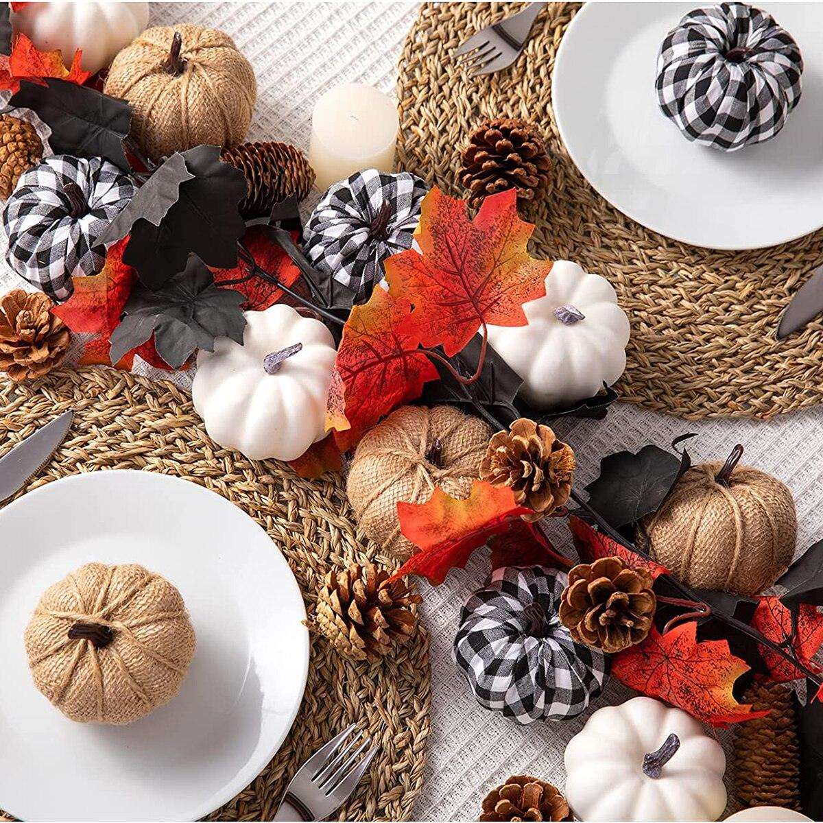 a table topped with white plates and fall decorations