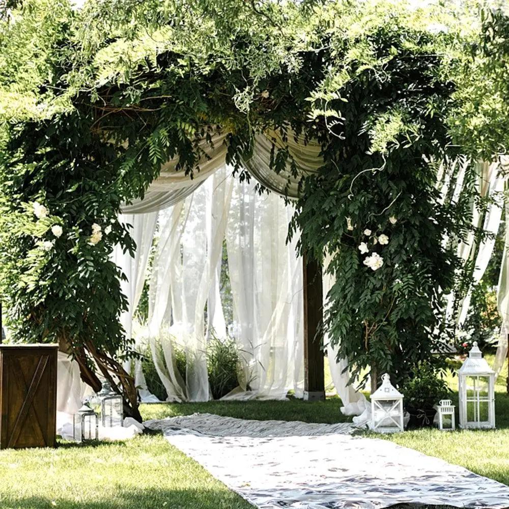 an outdoor wedding ceremony with a white drape and flowers