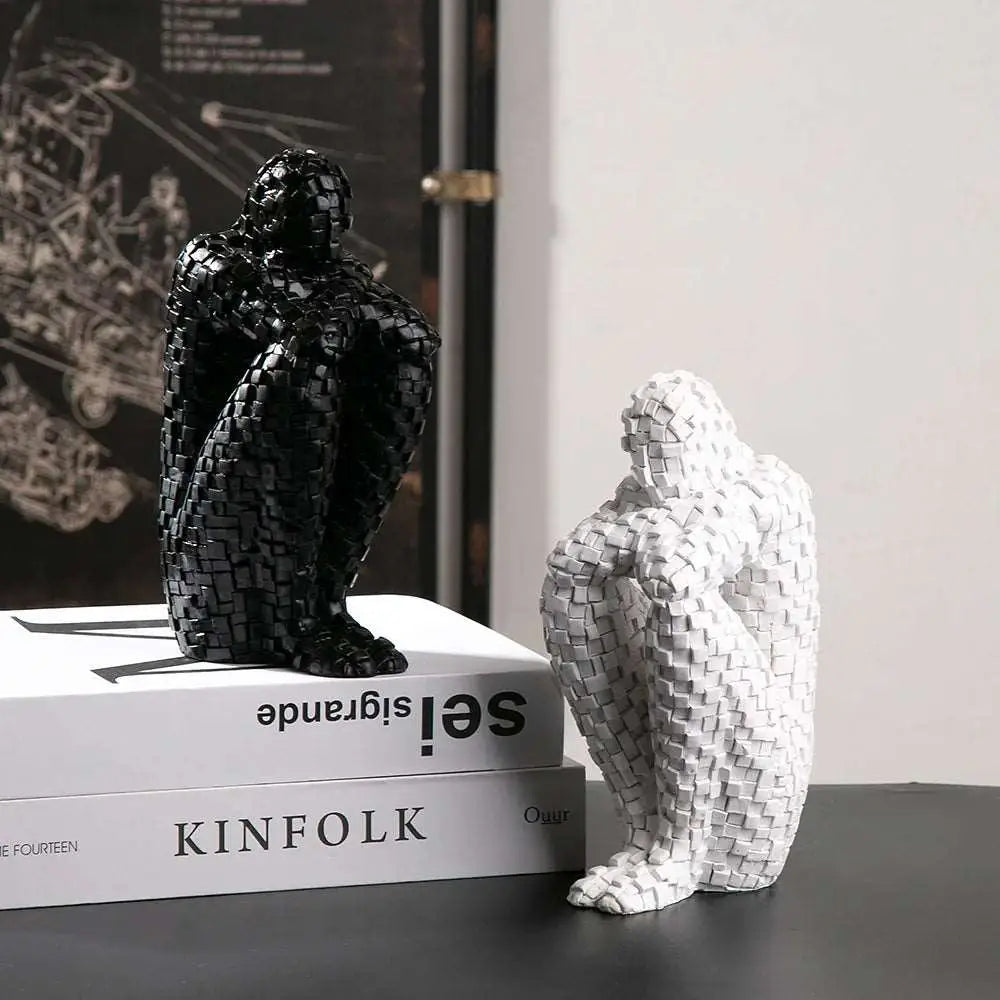 a couple of black and white sculptures sitting on top of a book