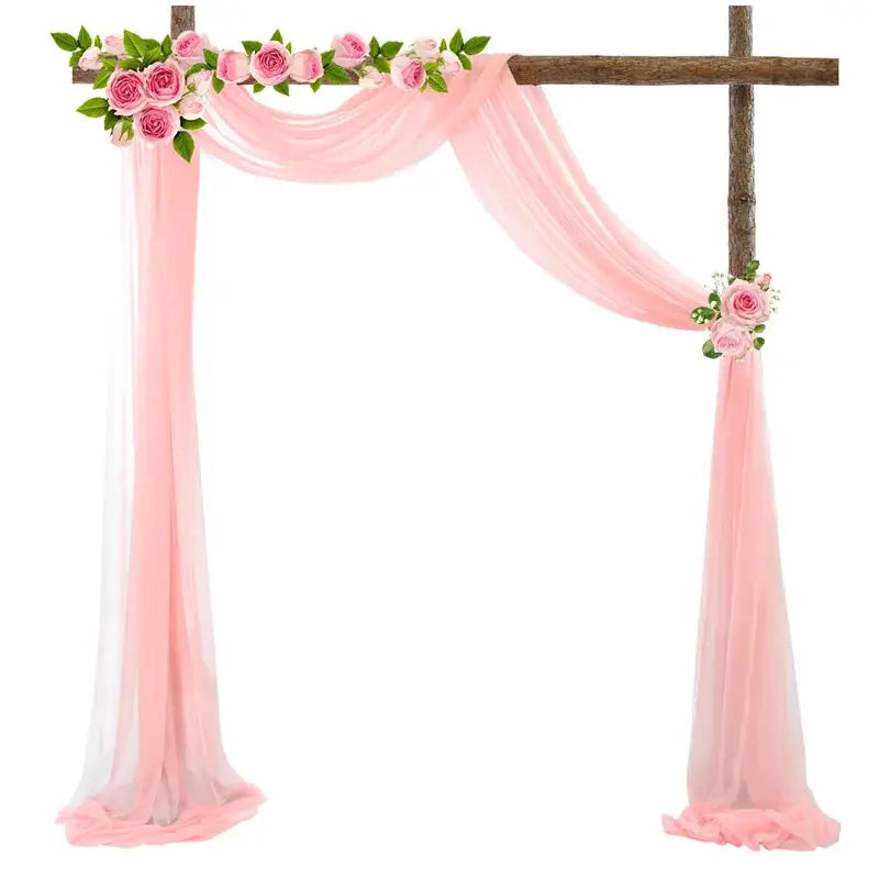 a pink wedding arch decorated with flowers and greenery