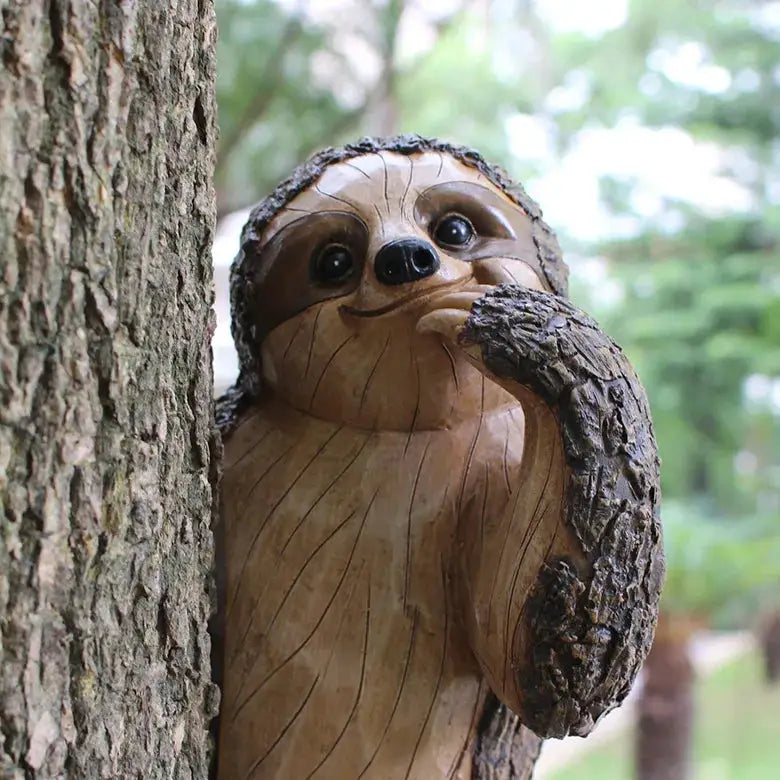 a carved wooden sloth sitting on top of a tree