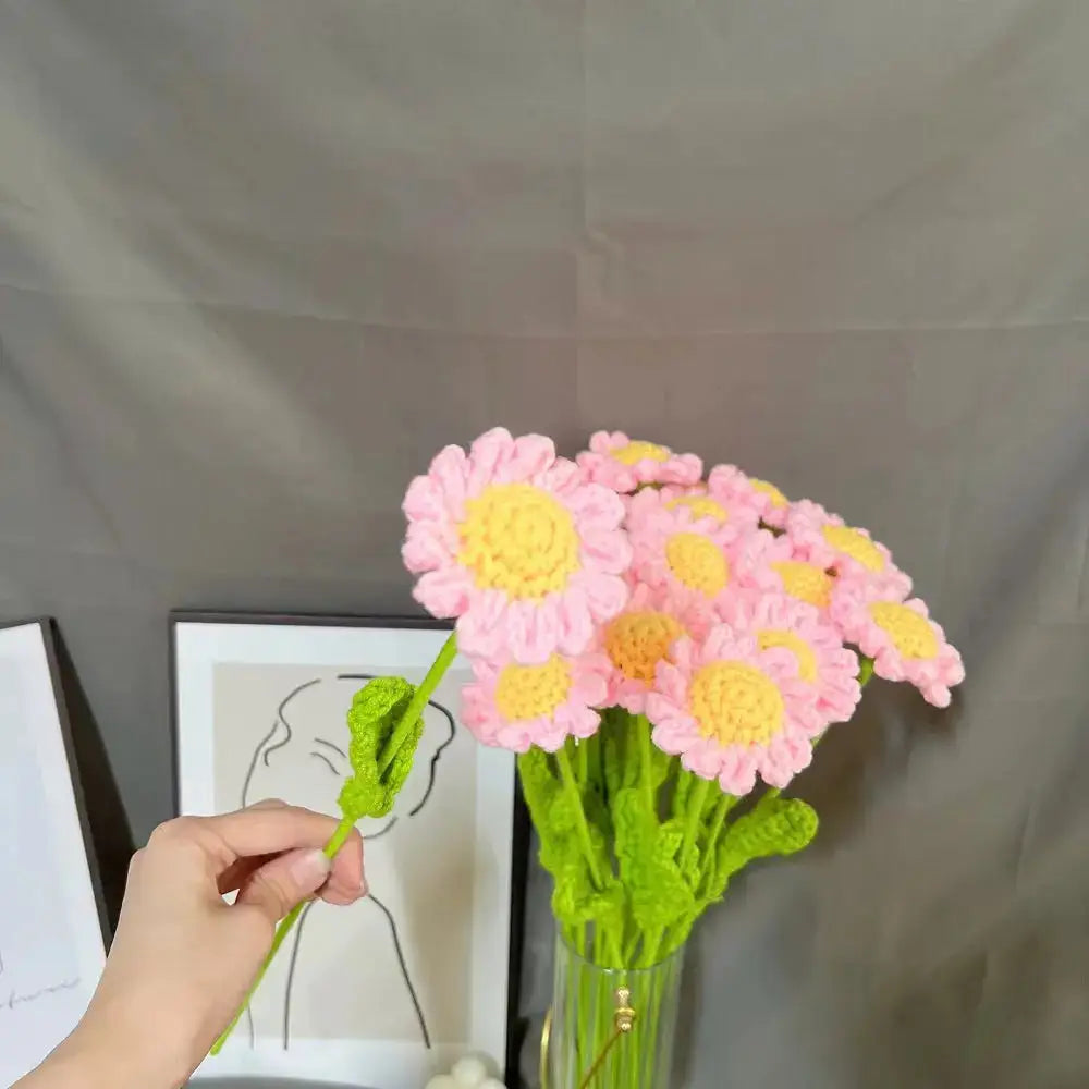 a person is holding a flower in a vase