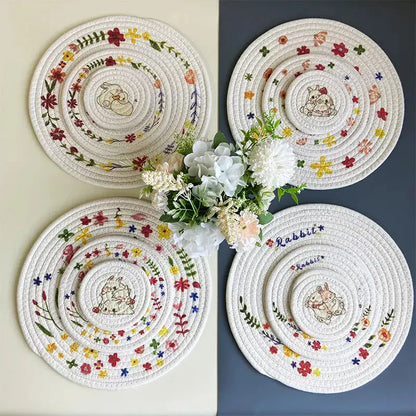 four white plates with flowers on them sitting on a table