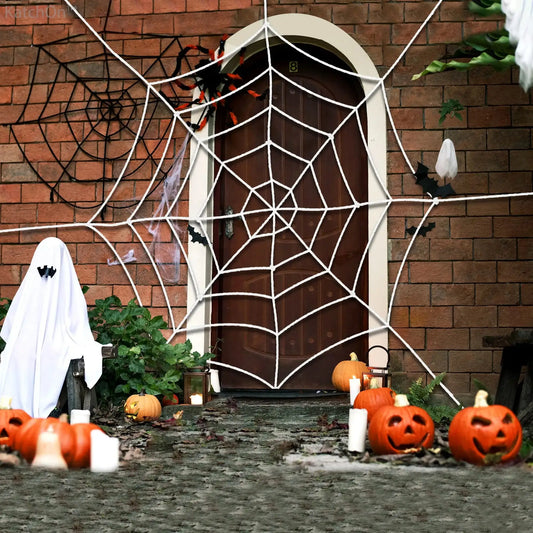 a house decorated for halloween with pumpkins and a spider web