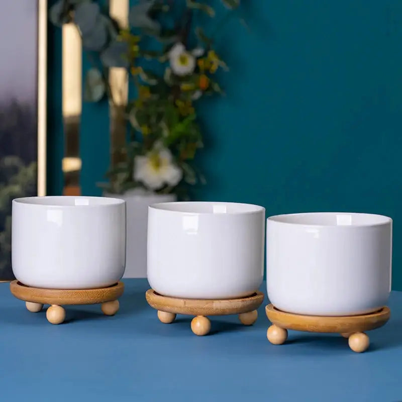 three white bowls sitting on top of a blue table
