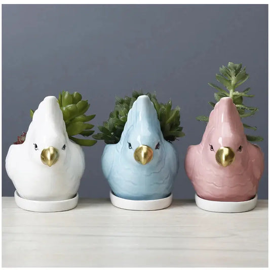 a group of three ceramic birds sitting next to each other