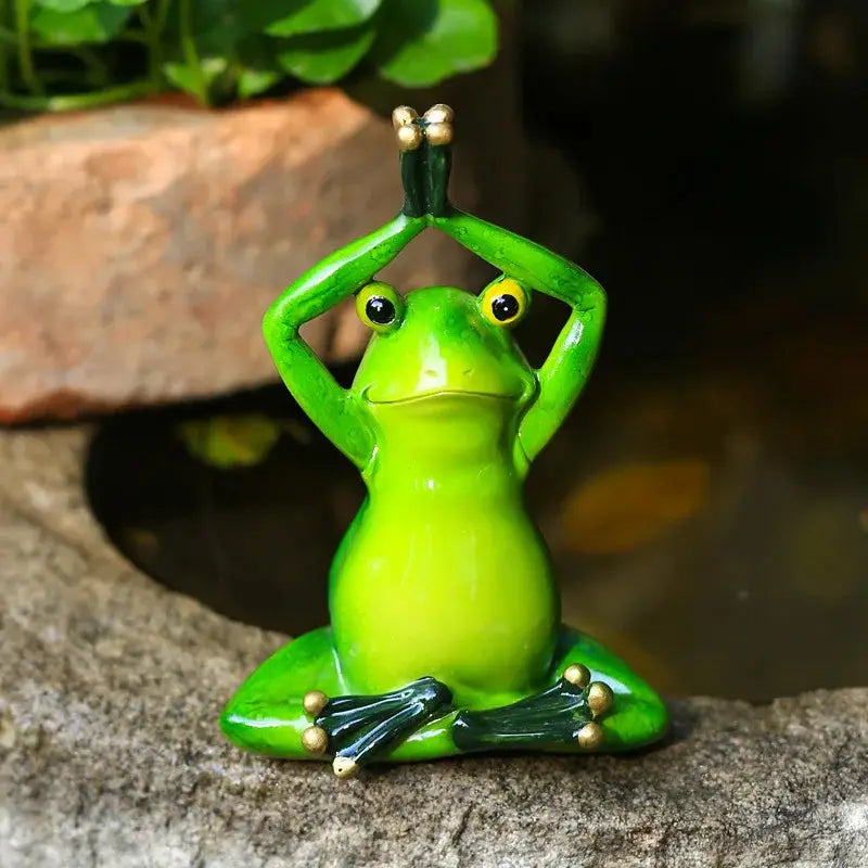 a green frog statue sitting on a rock