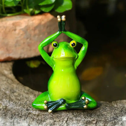 a green frog statue sitting on a rock