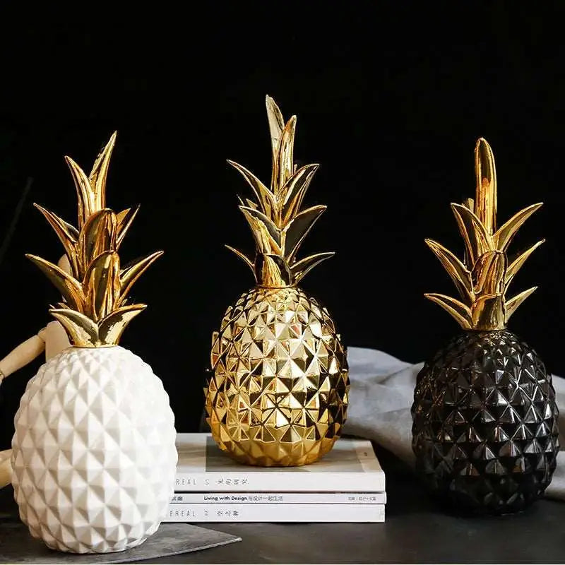 three gold pineapples are sitting on a stack of books