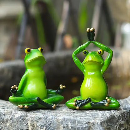 a couple of green frogs sitting on top of a rock
