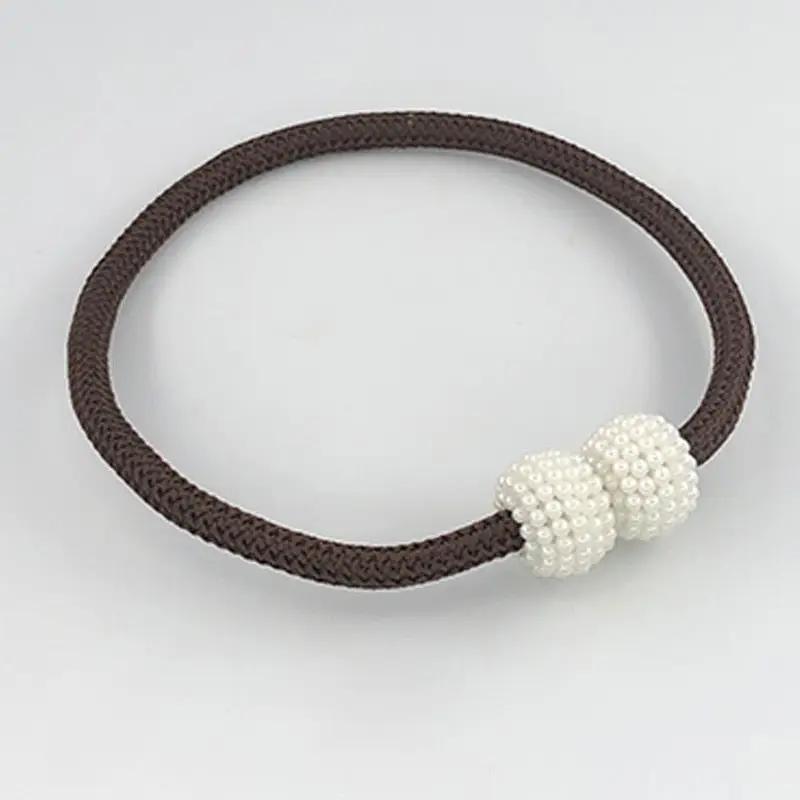 a white beaded bracelet on a brown cord