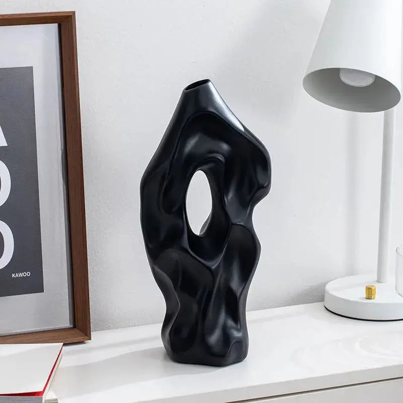 a black sculpture sitting on top of a white shelf