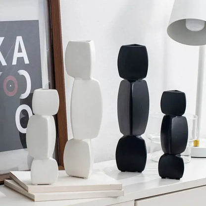 a group of black and white vases sitting on top of a table