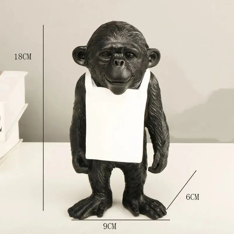 a statue of a monkey holding a piece of paper