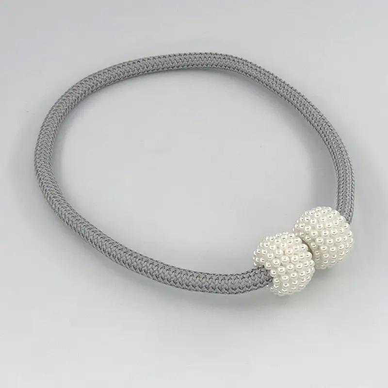 a gray and white bracelet with two beads