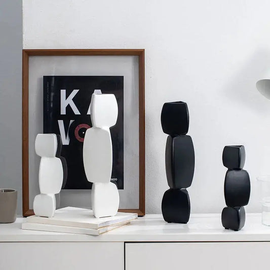 a group of black and white vases sitting on top of a white table