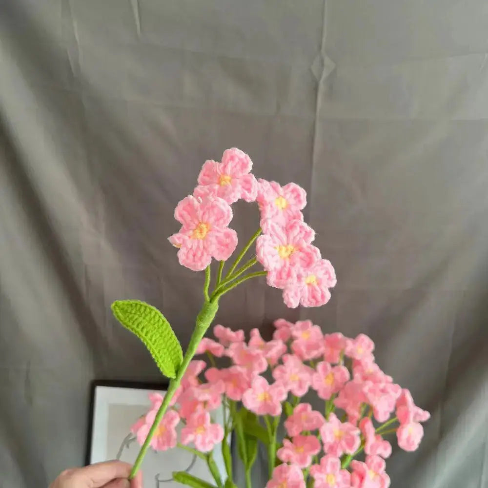 a person holding a vase with pink flowers in it