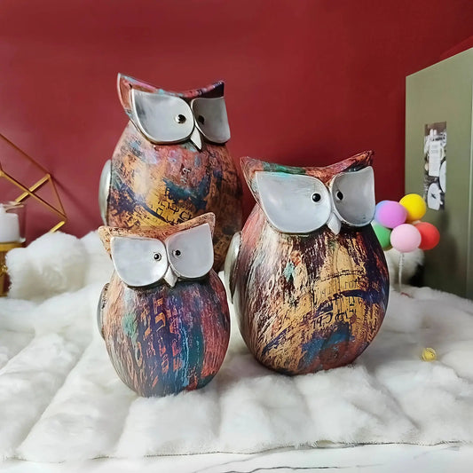 a couple of owls sitting on top of a white fur covered floor