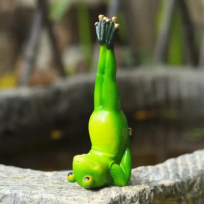 a green frog statue sitting on top of a rock