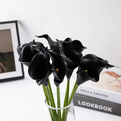 a vase filled with black flowers on top of a table