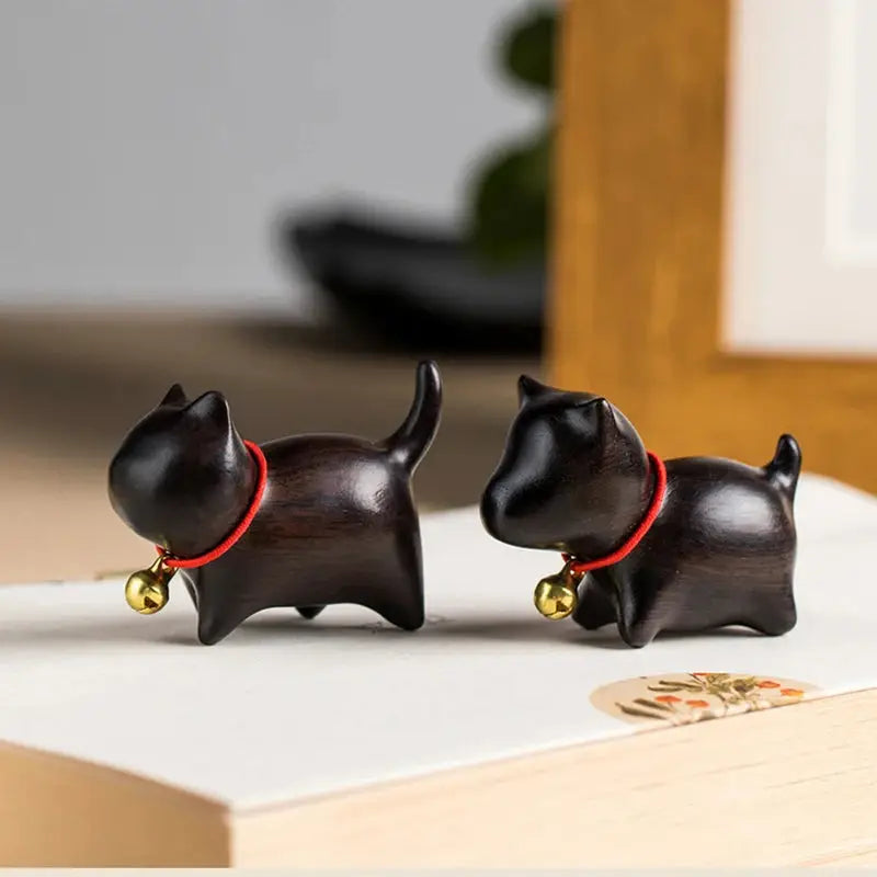 a pair of black cat figurines sitting on top of a table