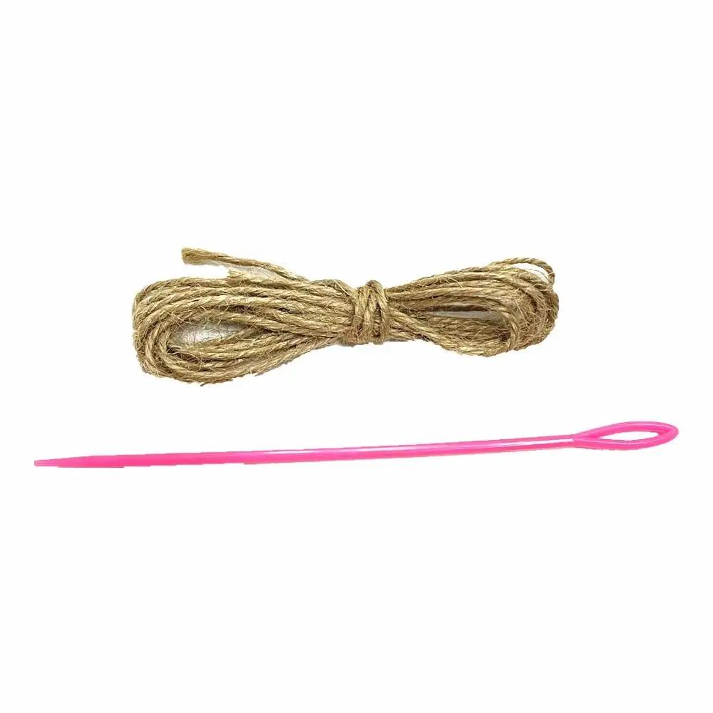 a pink knitting needle next to a piece of twine