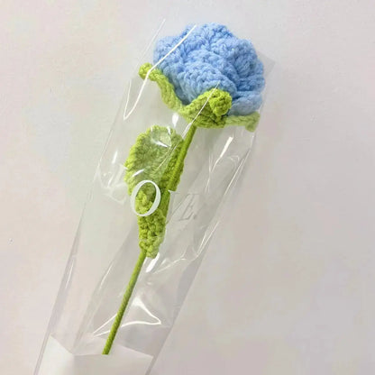 a crocheted blue and green flower in a plastic bag