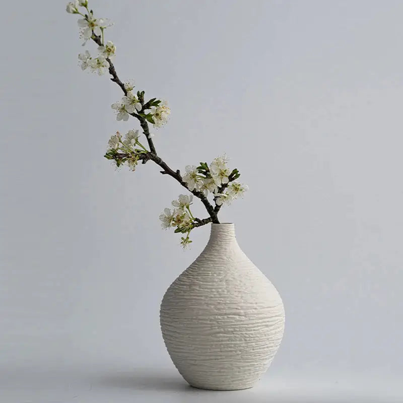a white vase with white flowers in it