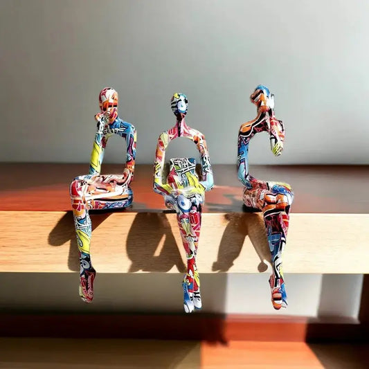 three colorful sculptures of people sitting on a bench
