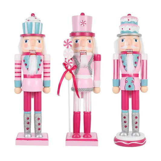 three wooden nutcrackers in pink and silver outfits
