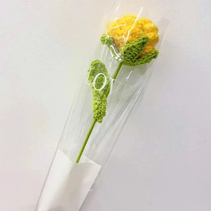 a crocheted flower in a clear vase