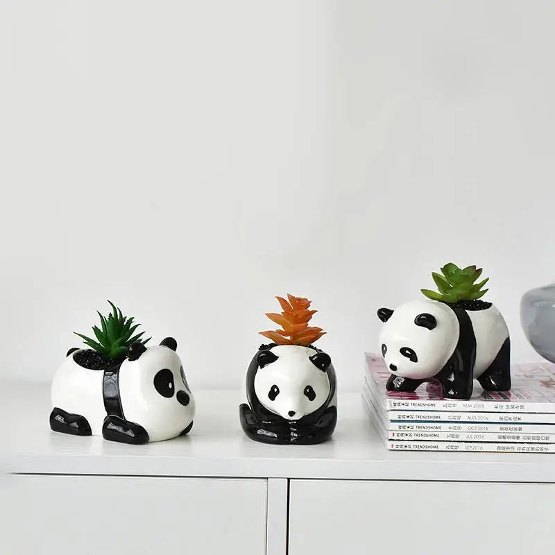 three ceramic panda bears with plants on their heads