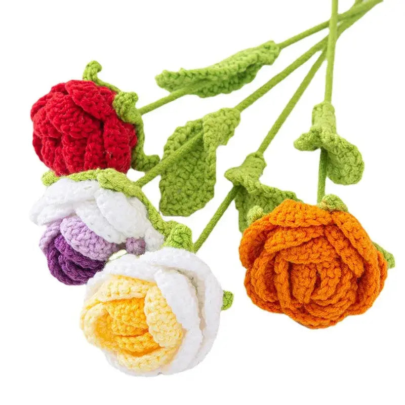a bunch of crocheted flowers hanging from a twig