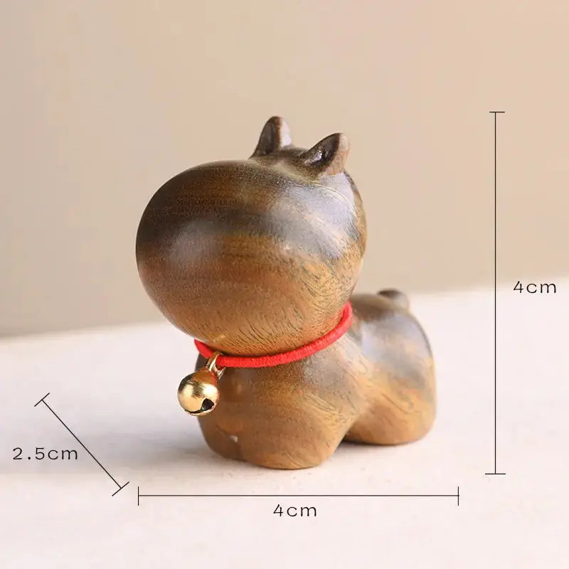 a wooden cat figurine with a bell around its neck