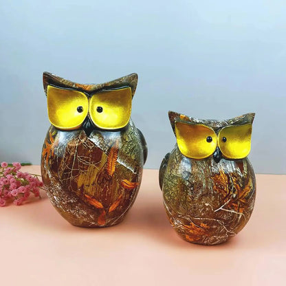 a couple of glass owls sitting on top of a table