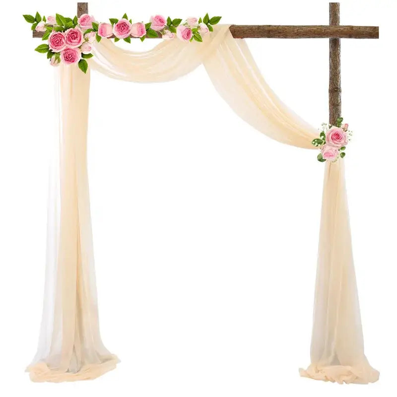 a wooden cross decorated with pink flowers and greenery